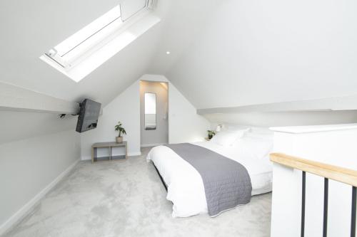 a white bedroom with a bed and a mirror at Blackwood in Hornsea