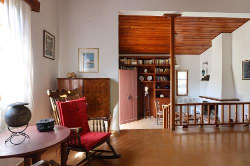 a living room with a table and chairs and a book shelf at Belle Epoque - Holiday Home in Aegina Town