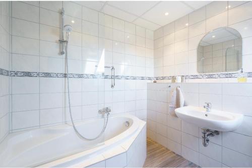 une salle de bain blanche avec une baignoire et un lavabo dans l'établissement SummerBreak 1 Scharbeutz, à Scharbeutz