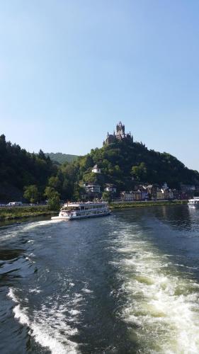 a boat on a river with a hill in the background at Weinhaus Berg in Bremm
