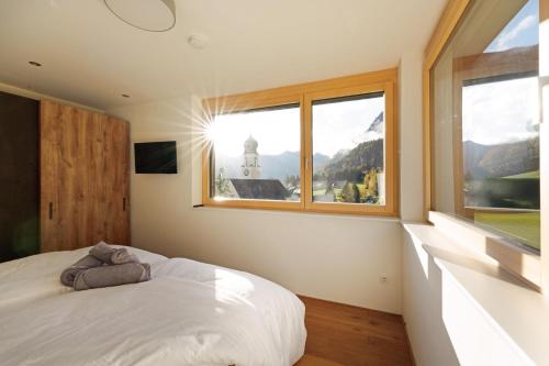 1 dormitorio con cama y ventana grande en Ferienwohnung "Urlaub am Arlberg", en Wald am Arlberg