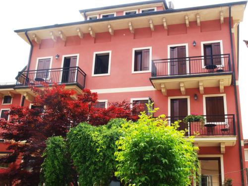 un bâtiment rouge avec des arbres devant lui dans l'établissement Albergo Al Castello, à Recoaro Terme