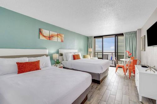 a hotel room with two beds and a balcony at Divine Vacay at this 1BR Oceanview Suite 828 in Myrtle Beach