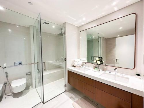 uma casa de banho com um chuveiro, um WC e um lavatório. em Soul Beach Relaxation! 112MB1 em Abu Dhabi