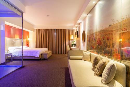 una camera d'albergo con letto e divano di Tenuta Contessa - Relais & Spa a Montalto Uffugo