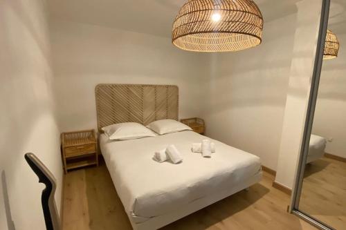 une chambre avec un lit avec des draps blancs et des oreillers dans l'établissement Appartement 2 pièces (Banane), à Cannes