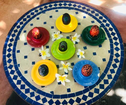 a plate with four colorful bowls and flowers on it at ParadiseGarden Backpackers in Windhoek