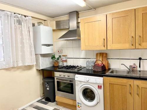 uma cozinha com um fogão e uma máquina de lavar roupa em 3BR Central London close to Piccadily Line em Londres