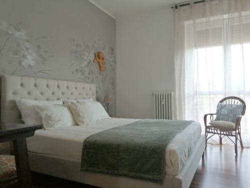 1 dormitorio con 1 cama, 1 silla y 1 ventana en Casa di Enri, en Como