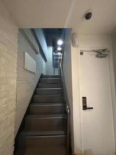 a hallway with stairs in a building with a door at Hotel Soo in Seoul