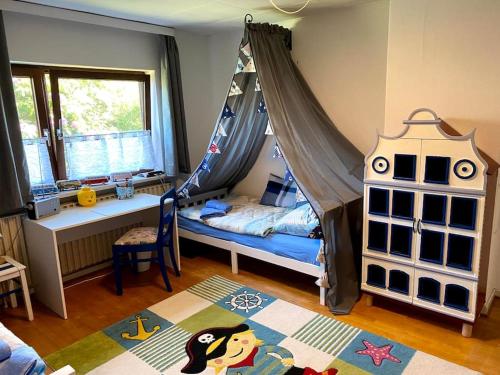um quarto para crianças com uma cama de dossel e um berço em Opa´s Häuschen em Westerholz