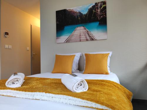 une chambre avec un lit avec des serviettes dessus dans l'établissement Le LUX 31, à Thionville