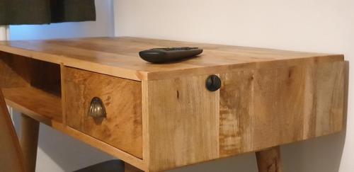 a remote control sitting on top of a wooden table at Comfort Stay Rooms in Portslade