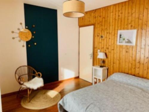 a bedroom with a bed and a chair in it at La Maison de Marie « Le Rocher » in Saint-Bonnet-en-Champsaur