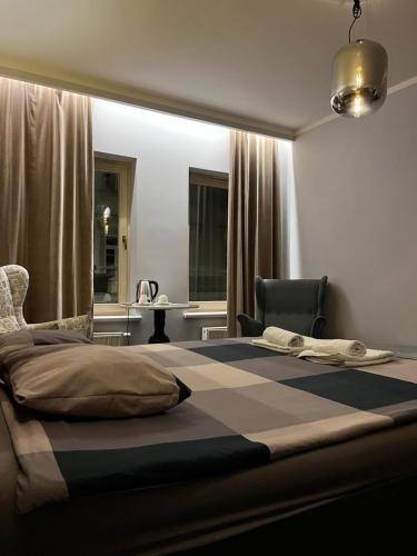 a bedroom with a bed and a chair and a table at Cosy Apartments Deluxe in Krakow