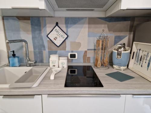 a kitchen with a sink and a counter top at Alloggio in residence con pontile privato e accesso diretto al mare in Santa Marinella