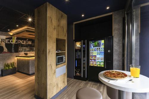 a pizza sitting on a table in a restaurant at Ibis Budget Valencia Alcasser in Silla