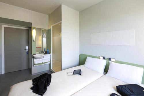 Un dormitorio con una cama con una bolsa negra. en Ibis Budget Valencia Alcasser, en Silla
