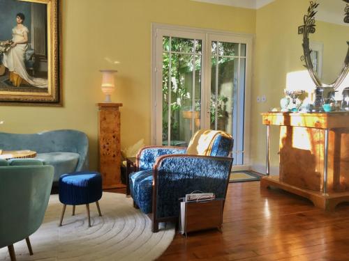 - un salon avec un canapé et une chaise dans l'établissement Le 1930, chambres d’hôtes de charme, à Cosne Cours sur Loire