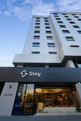 a building with a sign on the front of a store at Stey Beijing 798 Art Zone Hotel in Beijing