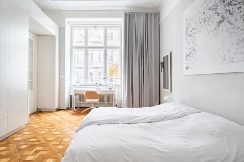 a white bedroom with a bed and a desk at Warsaw Center 110 m2 Spacious and Elegant Apartment in Warsaw