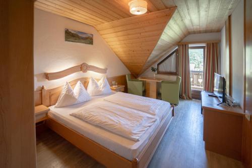 Habitación de hotel con cama y TV en Landhotel - Apartments Bauer, en Hintergöriach
