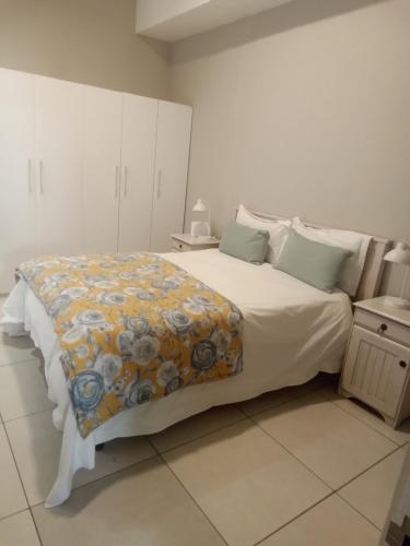 a bedroom with a large bed with a blanket on it at Franschhoek - La Petit Village - CENTRAL in Franschhoek
