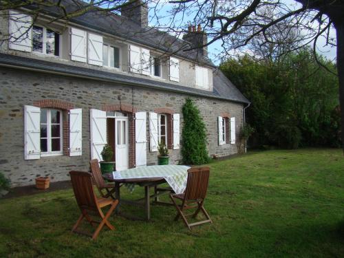 a table and chairs in front of a house at Entre Mont St Michel et Merveille in Vains