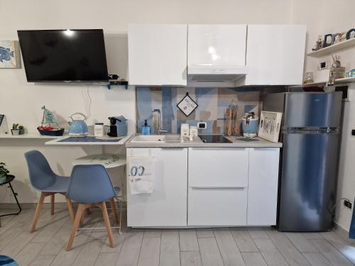 a kitchen with white cabinets and a refrigerator at Alloggio in residence con pontile privato e accesso diretto al mare in Santa Marinella