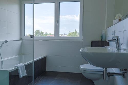 a bathroom with a sink and a toilet and a tub at Ferienhaus Seezeichen in Wasserburg am Bodensee