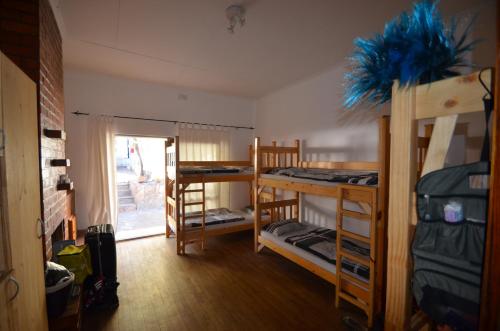 a room with three bunk beds and a doorway at ParadiseGarden Backpackers in Windhoek
