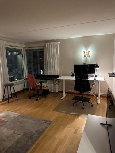 a living room with a desk and a piano at Trevlig lägenhet i Kista in Stockholm