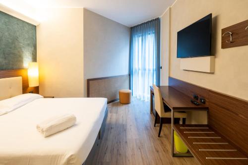 a hotel room with a bed and a desk at Hotel Des Etrangers in Milan