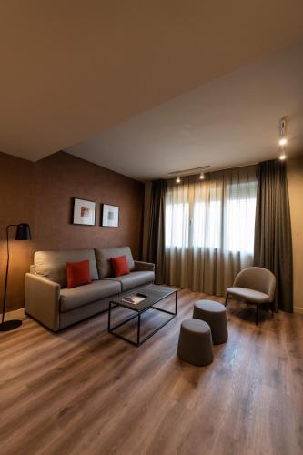 a living room with a couch and a table at Atenea Rekord Suites Barcelona in Barcelona