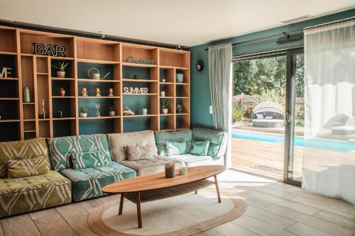 a living room with a couch and a coffee table at VILLA DREAM LANDES Piscine tempérée-Jacuzzi-5 suites parentales in Moliets-et-Maa