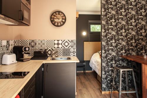 a kitchen with a sink and a clock on the wall at VILLA DREAM LANDES Piscine tempérée-Jacuzzi-5 suites parentales in Moliets-et-Maa