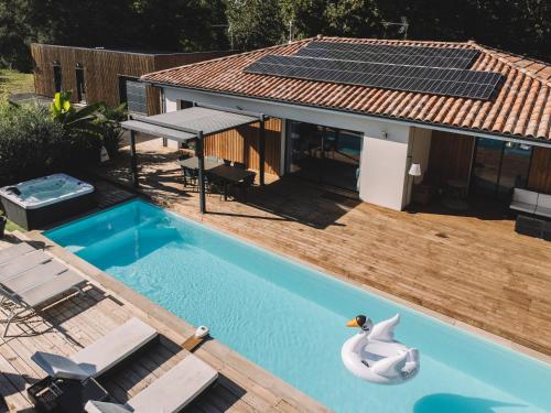 a swimming pool with a swan in front of a house at VILLA DREAM LANDES Piscine tempérée-Jacuzzi-5 suites parentales in Moliets-et-Maa