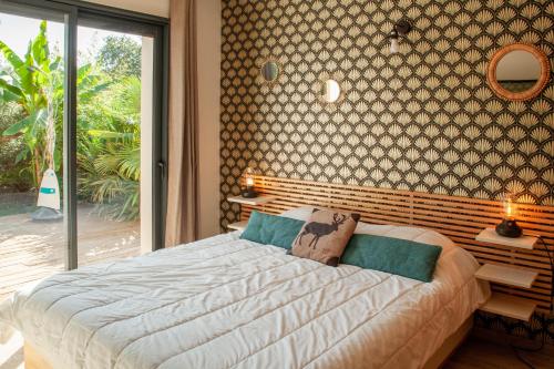 a bedroom with a large bed and a large window at VILLA DREAM LANDES Piscine tempérée-Jacuzzi-5 suites parentales in Moliets-et-Maa