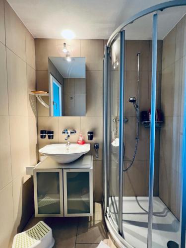 a bathroom with a sink and a shower at Chalet Windegg - CharmingStay in Flumserberg