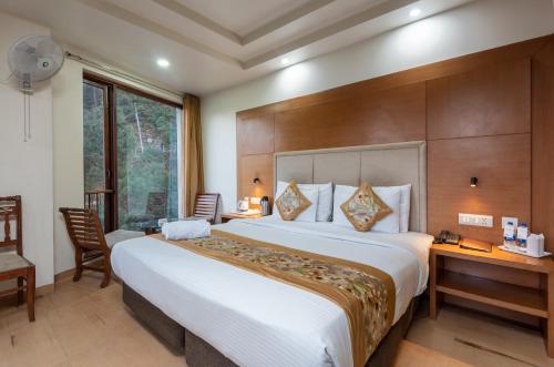una camera con un grande letto e una scrivania di Rock Castle By DLS Hotels a Shimla