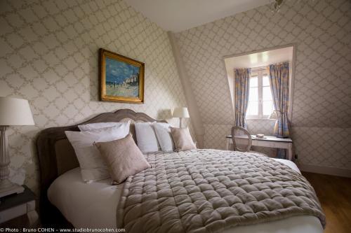 a bedroom with a large bed with white pillows at Le Château de la Tour in Gouvieux