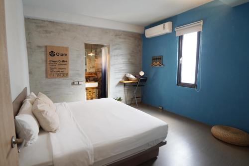 a bedroom with a white bed and blue walls at 山森三室墾丁包棟民宿3Rooms in Nanwan