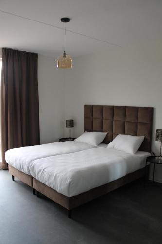 um quarto com uma cama grande e uma grande cabeceira. em Trompstraat Eindhoven em Eindhoven