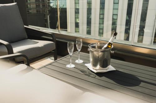 una mesa con dos copas y una botella de vino en The Londoner Hotel St. Julian's en St Julian's