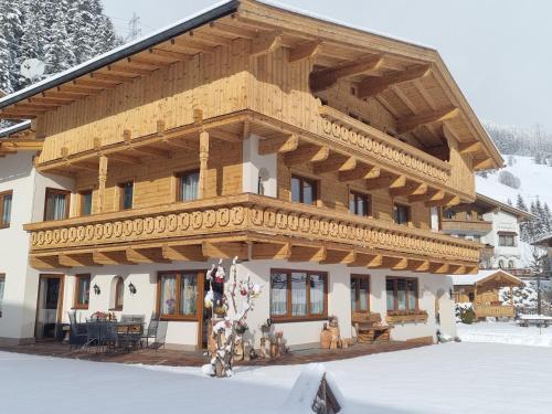 a large house with a wooden roof in the snow at Haus Daniela in Gerlos