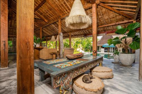 an outdoor room with a table and a bench at Villa Almar in Dalung