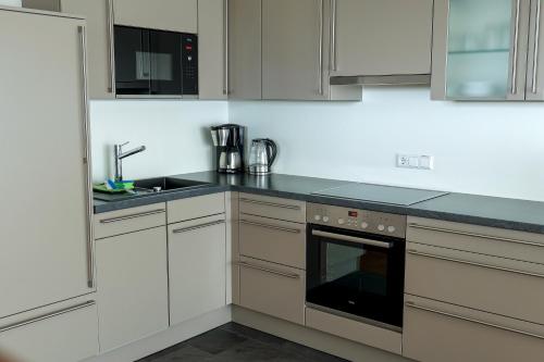 a kitchen with white cabinets and a sink at Ferienhaus Seezeichen in Wasserburg am Bodensee