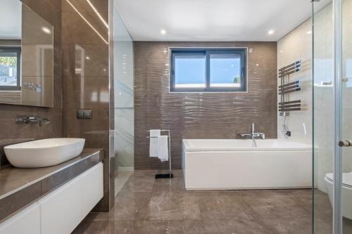 a bathroom with a white tub and a sink at Villa Boa Nova Verde by LovelyStay in Funchal