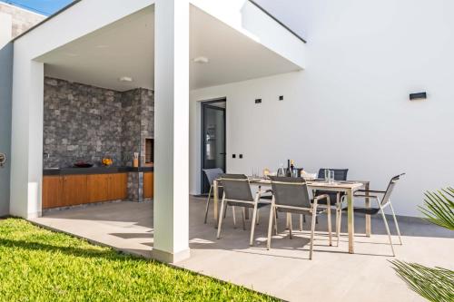 a patio with a table and chairs on a lawn at Villa Boa Nova Verde by LovelyStay in Funchal