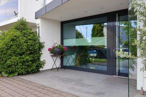 a glass door of a building with a plant at Ferienhaus Seezeichen in Wasserburg am Bodensee